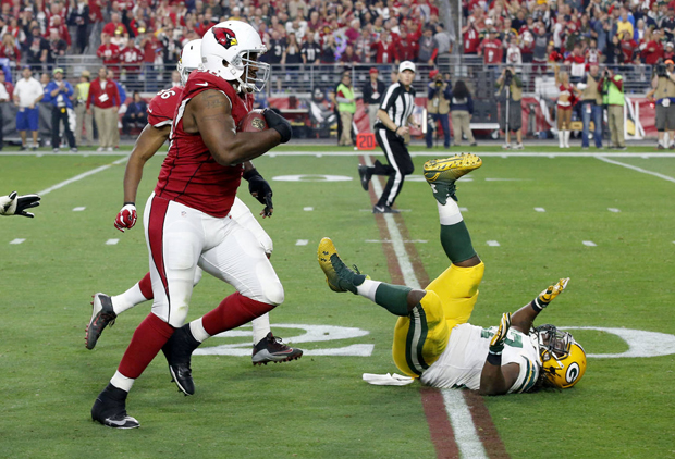 Arizona Cardinals defensive end Cory Redding (90) runs in a fumble recovery for a touchdown as Green Bay Packers running back Eddie Lacy (27) falls to the turf during the second half of an NFL football game, Sunday, Dec. 27, 2015, in Glendale, Ariz. (AP Photo/Ross D. Franklin)