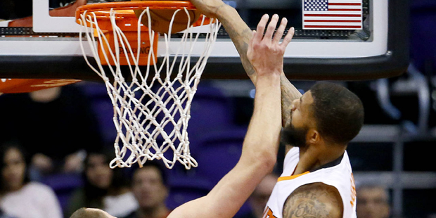 Phoenix Suns' Markieff Morris dunks over Toronto Raptors' Jonas Valanciunas, of Lithuania, (17) dur...