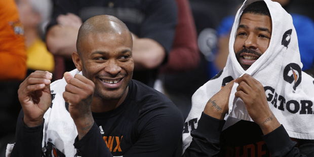 Phoenix Suns forwards P.J. Tucker, left, and Markieff Morris smile as they sit on the bench as the ...
