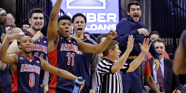 Arizona players react from the bench on a three-point score against Washington late in the second h...