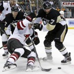 Arizona Coyotes' Michael Stone, left, falls to the ice while battling Pittsburgh Penguins' Matt Cullen (7) for the puck during the second period of an NHL hockey game in Pittsburgh, Monday, Feb. 29, 2016. (AP Photo/Gene J. Puskar)