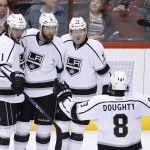 Los Angeles Kings' Jake Muzzin, second from left, celebrates his goal against the Arizona Coyotes with Anze Kopitar (11), of Slovenia; Drew Doughty (8); and Tyler Toffoli (73) during the second period of an NHL hockey game Tuesday, Feb. 2, 2016, in Glendale, Ariz. (AP Photo/Ross D. Franklin)