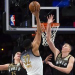 
              U.S. forward Karl-Anthony Towns (32) drives to the net past World's Nikola Jokic (15) and Kristaps Porzingis (6) during the first half of the NBA Rising Stars Challenge basketball game in Toronto on Friday, Feb. 12, 2016. (Mark Blinch/The Canadian Press via AP)
            