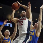 Arizona forward Ryan Anderson (12) shoots between UCLA's Bryce Alford, left, and Thomas Welsh during the second half of an NCAA college basketball game, Friday, Feb 12, 2016, in Tucson, Ariz. Arizona defeated UCLA 81-75. (AP Photo/Rick Scuteri)