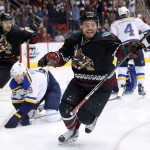 Arizona Coyotes' Max Domi, right, celebrates his goal as teammate Antoine Vermette, left, joins in as they both skate past St. Louis Blues' Jay Bouwmeester, second from left, during the third period of an NHL hockey game Saturday, Feb. 20, 2016, in Glendale, Ariz.  The Blues defeated the Coyotes 6-4. (AP Photo/Ross D. Franklin)