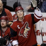 Arizona Coyotes' Shane Doan waves to a cheering crowd after Doan became the franchise leader in points with 930, during the third period of an NHL hockey game against the Calgary Flames Friday, Feb. 12, 2016, in Glendale, Ariz. A scoring change on a second-period goal game Doan an assist and the record. He scored a goal late in the third period to reach 931 point. The Coyotes defeated the Flames 4-1. (AP Photo/Ross D. Franklin)