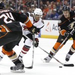 Arizona Coyotes left wing Anthony Duclair, center, weaves through Anaheim Ducks' Simon Despres (24) and Ryan Getzlaf (15) in the first period of an NHL hockey game in Anaheim, Calif., Friday, Feb. 5, 2016. (AP Photo/Christine Cotter)