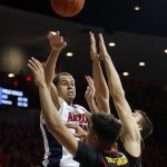 Arizona forward Ryan Anderson (12) shoots over Southern California forward Bennie Boatwright (25) and Katin Reinhardt during the second half of an NCAA college basketball game, Sunday, Feb. 14, 2016, in Tucson, Ariz. Arizona defeated Southern California 86-80. (AP Photo/Rick Scuteri)
