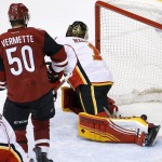 Calgary Flames' Jonas Hiller (1), of Switzerland, gives up a goal to Arizona Coyotes' Shane Doan as Coyotes' Antoine Vermette (50) and Flames' Mark Giordano (5) watch during the third period of an NHL hockey game Friday, Feb. 12, 2016, in Glendale, Ariz.  The Coyotes defeated the Flames 4-1. (AP Photo/Ross D. Franklin)