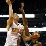 Phoenix Suns center Alex Len (21) shoots over San Antonio Spurs center Tim Duncan in the first quarter during an NBA basketball game, Sunday, Feb. 21, 2016, in Phoenix. (AP Photo/Rick Scuteri)