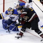 Arizona Coyotes' Shane Doan, front, gets the puck past St. Louis Blues' Brian Elliott (1) for a goal as Blues' Colton Parayko (55) defends during the first period of an NHL hockey game Saturday, Feb. 20, 2016, in Glendale, Ariz. (AP Photo/Ross D. Franklin)