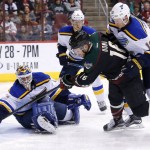 Arizona Coyotes' Max Domi (16) scores a goal against St. Louis Blues' Brian Elliott, left, as Blues' Jay Bouwmeester (19) defends, while Blues' Carl Gunnarsson (4), of Sweden, and Coyotes' Antoine Vermette (50) watch during the third period of an NHL hockey game Saturday, Feb. 20, 2016, in Glendale, Ariz.  The Blues defeated the Coyotes 6-4. (AP Photo/Ross D. Franklin)