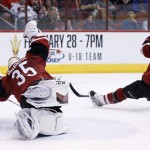 
              Arizona Coyotes' Louis Domingue (35) makes a diving save on a shot by Calgary Flames' T.J. Brodie (7) as Coyotes' Brad Richardson (12) also defends during the first period of an NHL hockey game Friday, Feb. 12, 2016, in Glendale, Ariz. (AP Photo/Ross D. Franklin)
            