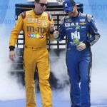 Dale Earnhardt Jr, right, bumps fists with Kyle Busch, left, as they are introduced before the start of the NASCAR Daytona 500 Sprint Cup Series auto race at Daytona International Speedway in Daytona Beach, Fla., Sunday, Feb. 21, 2016. (AP Photo/Wilfredo Lee)