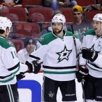 Dallas Stars' Tyler Seguin (91) celebrates his goal against the Arizona Coyotes with Jamie Benn (14) and Patrick Sharp (10) during the first period of an NHL hockey game Thursday, Feb. 18, 2016, in Glendale, Ariz. (AP Photo/Ross D. Franklin)