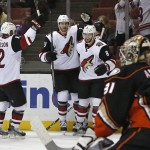 Arizona Coyotes' Brad Richardson (12), Jarred Tinordi, and Tobias Rieder (8) celebrate Rieders' goal as Anaheim Ducks goalie Frederik Andersen (31) looks away in the first period of an NHL hockey game in Anaheim, Calif., Friday, Feb. 5, 2016. (AP Photo/Christine Cotter)