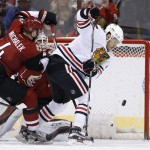Chicago Blackhawks' Artem Anisimov, right, of Russia, tries to get a stick on the puck as Arizona Coyotes' Zbynek Michalek (4), of the Czech Republic, defends during the second period of an NHL hockey game Thursday, Feb. 4, 2016, in Glendale, Ariz. (AP Photo/Ross D. Franklin)