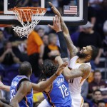 Phoenix Suns' Markieff Morris, right, gets fouled by Oklahoma City Thunder's Steven Adams, center, of New Zealand, as he goes up for a shot while Thunder's Kevin Durant, left, watches during the first half of an NBA basketball game Monday, Feb. 8, 2016, in Phoenix. (AP Photo/Ross D. Franklin)