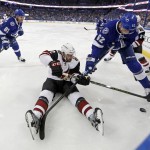 Arizona Coyotes' Brad Richardson tries to maintain control of the puck as he's checked by Tampa Bay Lightning's Andrej Sustr, of the Czech Republic, during the first period of an NHL hockey game Tuesday, Feb. 23, 2016, in Tampa, Fla. (AP Photo/Mike Carlson)