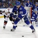 Tampa Bay Lightning's Matt Carle avoids the check of Arizona Coyotes' Viktor Tikhonov, of Latvia, during the first period of an NHL hockey game Tuesday, Feb. 23, 2016, in Tampa, Fla. (AP Photo/Mike Carlson)