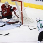 Dallas Stars' Jamie Benn (14) sends the puck at Arizona Coyotes' Louis Domingue (35) before it slips past the goalie for a score during the second period of an NHL hockey game Thursday, Feb. 18, 2016, in Glendale, Ariz. (AP Photo/Ross D. Franklin)