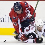 Washington Capitals defenseman Nate Schmidt (88) and Arizona Coyotes center Brad Richardson (12) fight for the puck during the first period of an NHL hockey game, on Monday, Feb. 22, 2016, in Washington. (AP Photo/Evan Vucci)