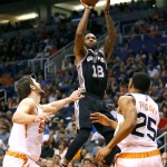 San Antonio Spurs forward Rasual Butler (18) shoots over Phoenix Suns forward Mirza Teletovic and guard Phil Pressey (25) in the fourth quarter of an NBA basketball game, Sunday, Feb. 21, 2016, in Phoenix. The Spurs won 118-111. (AP Photo/Rick Scuteri)