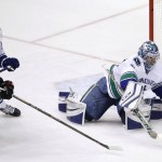 Vancouver Canucks' Ryan Miller, right, makes a save on a shot by Arizona Coyotes' Martin Hanzal (11), of the Czech Republic, as Canucks' Adam Cracknell defends during the third period of an NHL hockey game Wednesday, Feb. 10, 2016, in Glendale, Ariz. The Canucks defeated the Coyotes 2-1. (AP Photo/Ross D. Franklin)