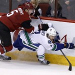 Arizona Coyotes' Connor Murphy (5) sends Vancouver Canucks' Chris Tanev, right, to the ice during the third period of an NHL hockey game Wednesday, Feb. 10, 2016, in Glendale, Ariz. The Canucks defeated the Coyotes 2-1. (AP Photo/Ross D. Franklin)