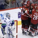 Arizona Coyotes' Martin Hanzal (11), of the Czech Republic, rear, celebrates with Anthony Duclair (10), Michael Stone (26), Max Domi (16), and Oliver Ekman-Larsson (23), of Sweden, his goal against Vancouver Canucks' Ryan Miller (30) during the second period of an NHL hockey game Wednesday, Feb. 10, 2016, in Glendale, Ariz. (AP Photo/Ross D. Franklin)