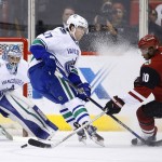 Arizona Coyotes' Anthony Duclair (10) tries to get off a shot past Vancouver Canucks' Ben Hutton (27) as Canucks' goalie Ryan Miller (30) gets in position for the save during the first period of an NHL hockey game Wednesday, Feb. 10, 2016, in Glendale, Ariz. (AP Photo/Ross D. Franklin)