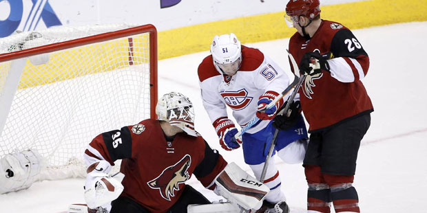 Arizona Coyotes' Louis Domingue (35) makes a save on a shot as Montreal Canadiens' David Desharnais...