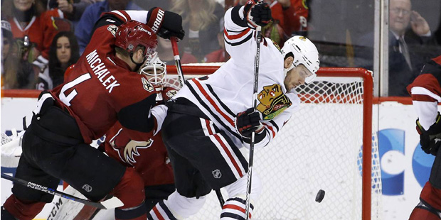 Chicago Blackhawks' Artem Anisimov, right, of Russia, tries to get a stick on the puck as Arizona C...