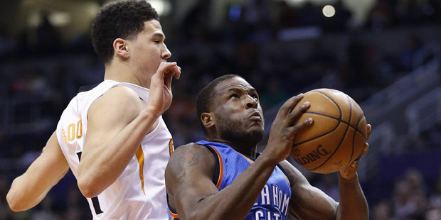 Oklahoma City Thunder's Dion Waiters (3) drives past Phoenix Suns' Devin Booker, left, for a dunk d...