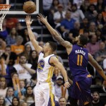 Golden State Warriors' Stephen Curry scores against Phoenix Suns' Markieff Morris (11) during the second half of an NBA basketball game, Wednesday, Feb. 10, 2016, in Phoenix. (AP Photo/Matt York)