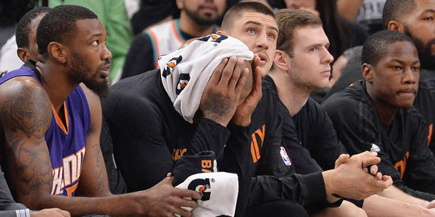 Phoenix Suns players watch play from the bench during the first half of an NBA basketball game agai...