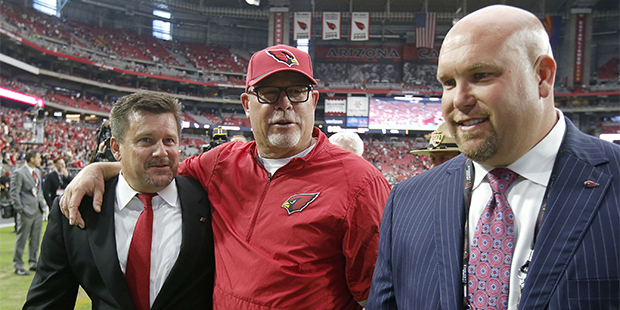 Arizona Cardinals team president Michael Bidwill, left, walks off the field with head coach Bruce A...