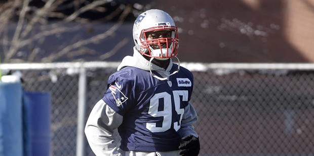 New England Patriots defensive lineman Chandler Jones warms up on the field during an NFL football ...