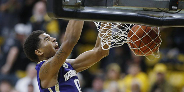 Washington forward Marquese Chriss, right, reacts as he dunks the ball for a basket over Colorado f...
