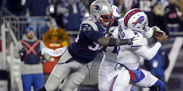 Buffalo Bills quarterback Tyrod Taylor, right, eludes New England Patriots defensive end Chandler J...