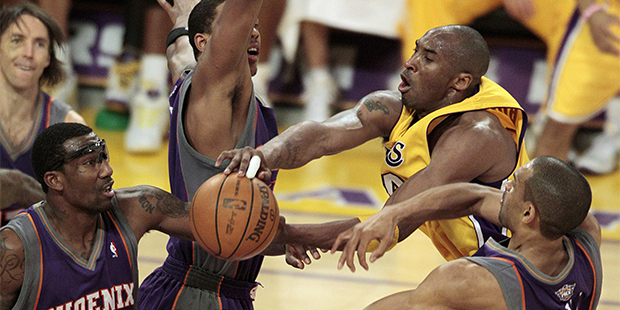 Los Angeles Lakers guard Kobe Bryant, right, passes as he is defended by Phoenix Suns' Grant Hill, right, Amare Stoudemire (1) and Channing Frye during the first half in Game 1 of the NBA Western Conference basketball finals in Los Angeles, Monday, May 17, 2010. (AP Photo/Jae C. Hong)