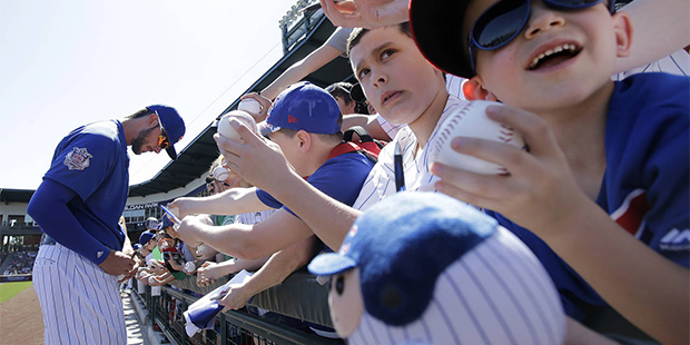 Chicago Cubs third baseman Kris Bryant signs autographs for fans before a spring training baseball ...