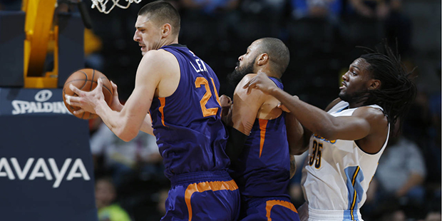 Phoenix Suns center Alex Len, left, of the Ukraine, pulls in a rebound in front of center Tyson Cha...