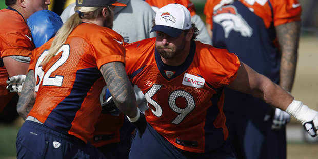 Denver Broncos guard Evan Mathis, right, squares off with practice squad center Dillon Day during a...