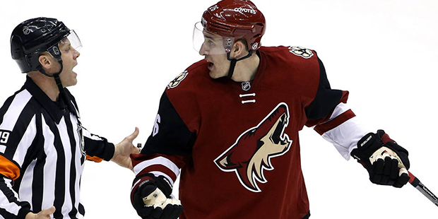 Arizona Coyotes' Michael Stone, right, argues a penalty with referee Gord Dwyer (19) during the thi...