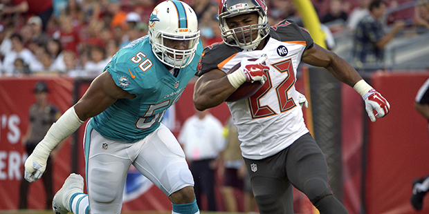 Tampa Bay Buccaneers running back Doug Martin (22) eludes Miami Dolphins defensive end Olivier Vern...