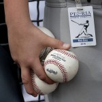 A bat boy holds game balls before a spring training baseball game between the Seattle Mariners and the Arizona Diamondbacks Monday, March 7, 2016, in Peoria, Ariz. (AP Photo/Charlie Riedel)