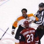 Philadelphia Flyers' Wayne Simmonds (17) is restrained by linesman Greg Devorski (54) as Arizona Coyotes' Oliver Ekman-Larsson (23), of Sweden, shouts back at Simmonds during the third period of an NHL hockey game Saturday, March 26, 2016, in Glendale, Ariz. The Coyotes defeated the Flyers 2-1. (AP Photo/Ross D. Franklin)