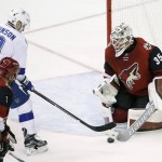 Arizona Coyotes' Louis Domingue (35) makes save on a shot by Tampa Bay Lightning's Tyler Johnson (9) as Coyotes' Nicklas Grossmann (2) moves in to defend during the second period of an NHL hockey game Saturday, March 19, 2016, in Glendale, Ariz. (AP Photo/Ross D. Franklin)