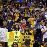 Fans hold signs and take pictures of Los Angeles Lakers forward Kobe Bryant prior to an NBA basketball game against the Phoenix Suns, Wednesday, March 23, 2016, in Phoenix. (AP Photo/Matt York)